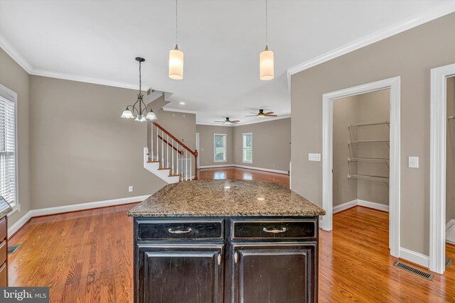 kitchen with visible vents, baseboards, crown molding, and light wood-style floors