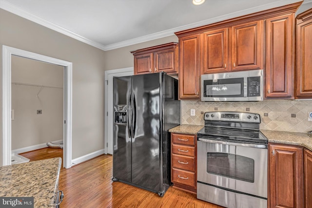 kitchen featuring decorative backsplash, appliances with stainless steel finishes, baseboards, light stone counters, and ornamental molding