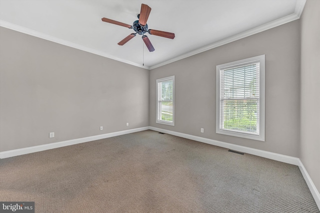 carpeted empty room featuring baseboards, a ceiling fan, crown molding, and visible vents