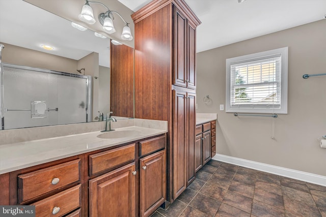 full bathroom featuring walk in shower, baseboards, stone finish floor, and vanity
