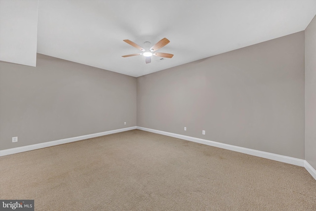 carpeted empty room with baseboards and a ceiling fan