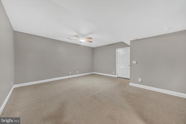 unfurnished room with light colored carpet, a ceiling fan, and baseboards