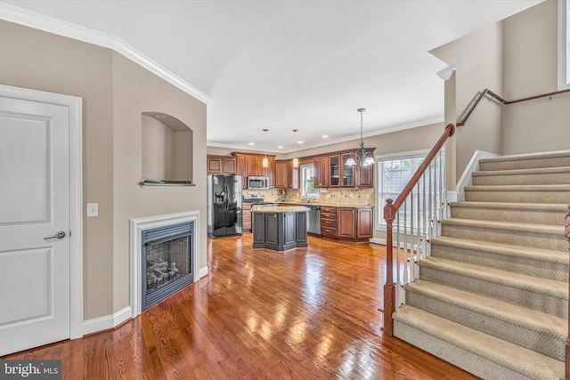 interior space featuring ornamental molding, stairs, and wood finished floors