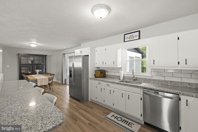 1004 Marietta Ave, Hanover, PA 17331 - kitchen featuring stainless steel appliances, a sink, backsplash, white cabinets, and light wood-style flooring