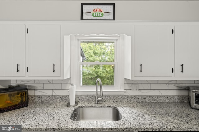 1004 Marietta Ave, Hanover, PA 17331 - kitchen featuring a sink, white cabinetry, decorative backsplash, and light stone counters