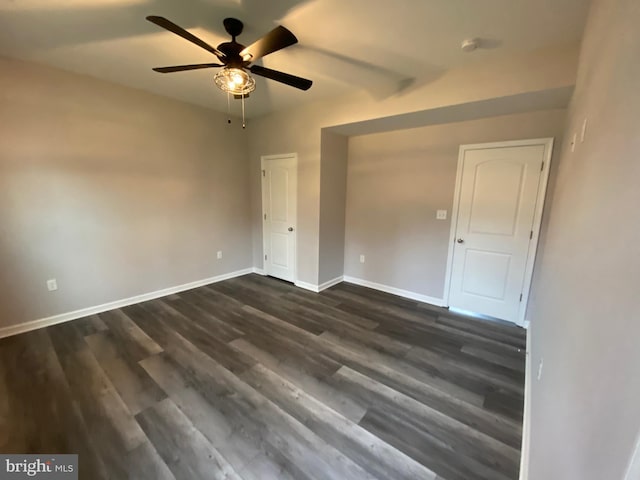 unfurnished bedroom with baseboards, a ceiling fan, and dark wood-style floors