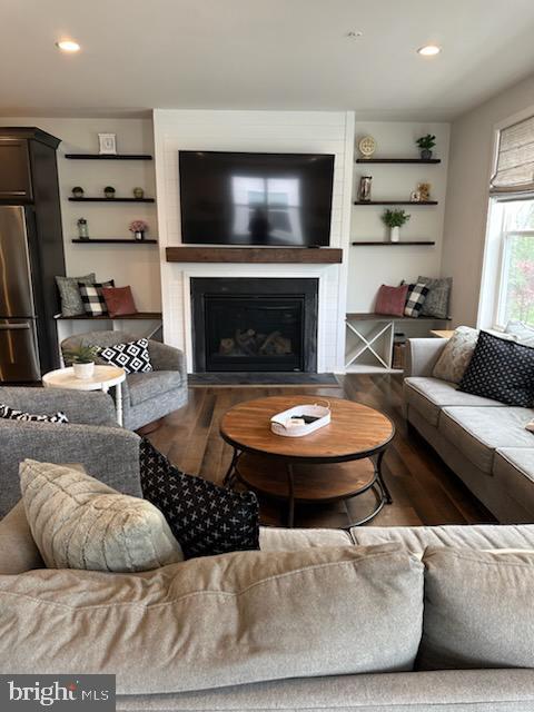 living area featuring recessed lighting, wood finished floors, and a fireplace