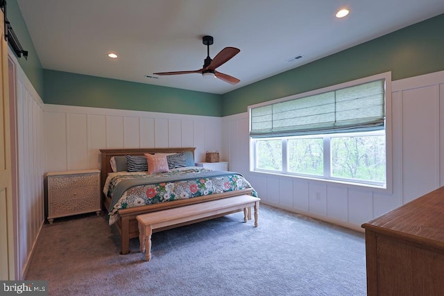 bedroom featuring ceiling fan, visible vents, carpet floors, a decorative wall, and recessed lighting