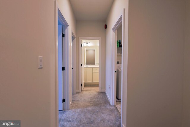 corridor featuring baseboards and carpet