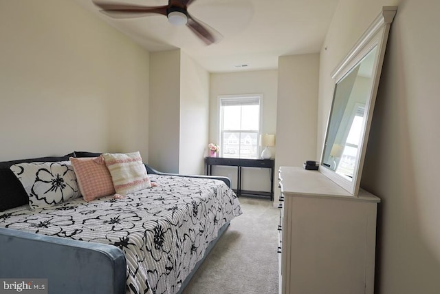 bedroom featuring ceiling fan, light colored carpet, and visible vents