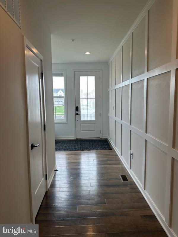 doorway to outside with dark wood-style flooring, baseboards, visible vents, and recessed lighting