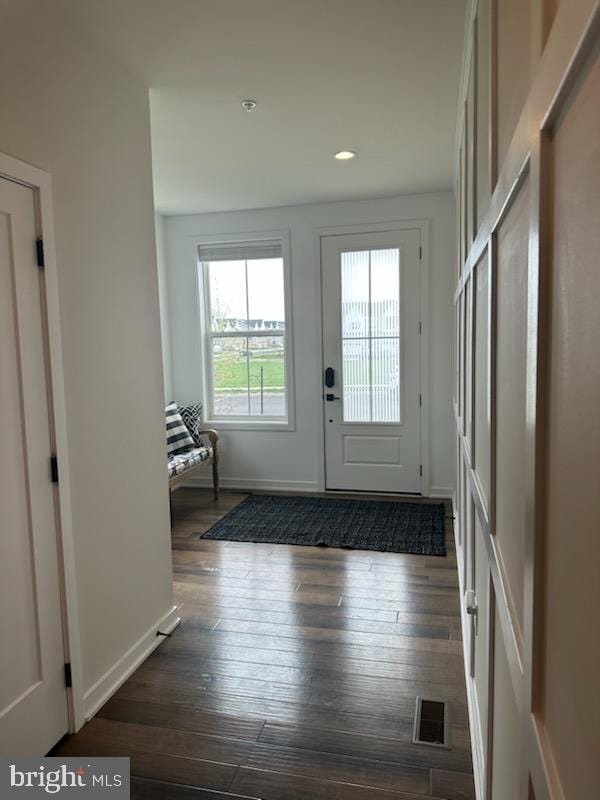 entryway with dark wood finished floors, baseboards, recessed lighting, and visible vents