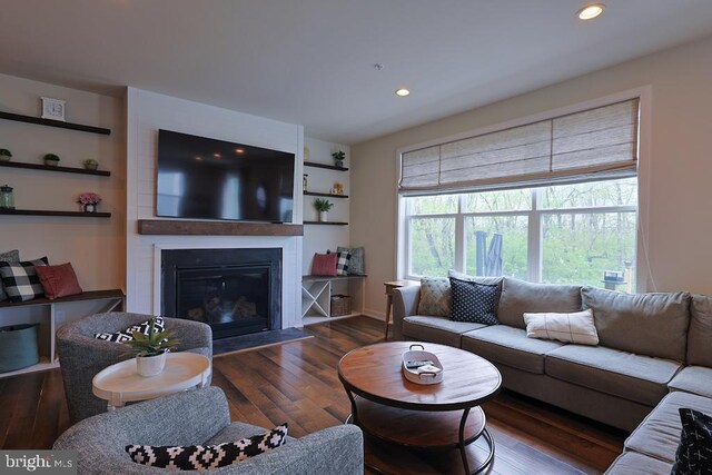 living room with recessed lighting, baseboards, a large fireplace, and wood finished floors