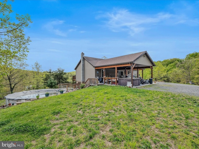 749 Poland Hollow Rd, Romney, WV 26757 - rear view of house with a swimming pool, a chimney, a wooden deck, a hot tub, and a yard