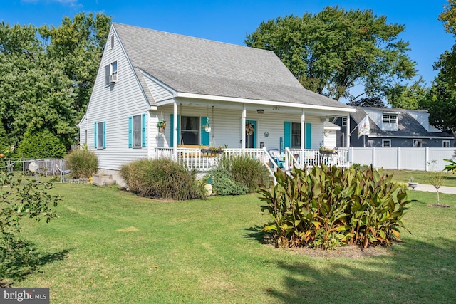 view of front of home featuring a porch, fence, and a front yard