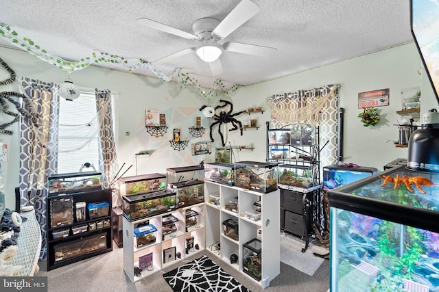 game room featuring carpet, a textured ceiling, and ceiling fan