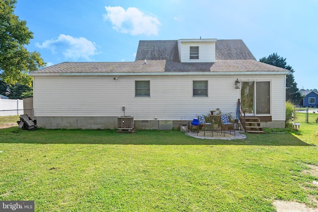 back of house with entry steps, fence, and a yard