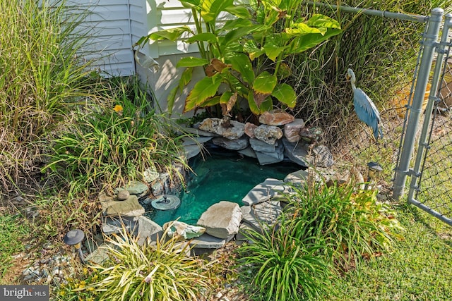 exterior details with a small pond and fence