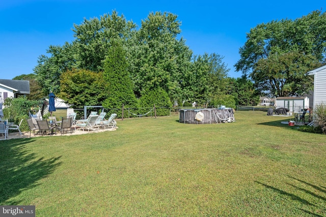 view of yard with a patio, an outdoor pool, and fence