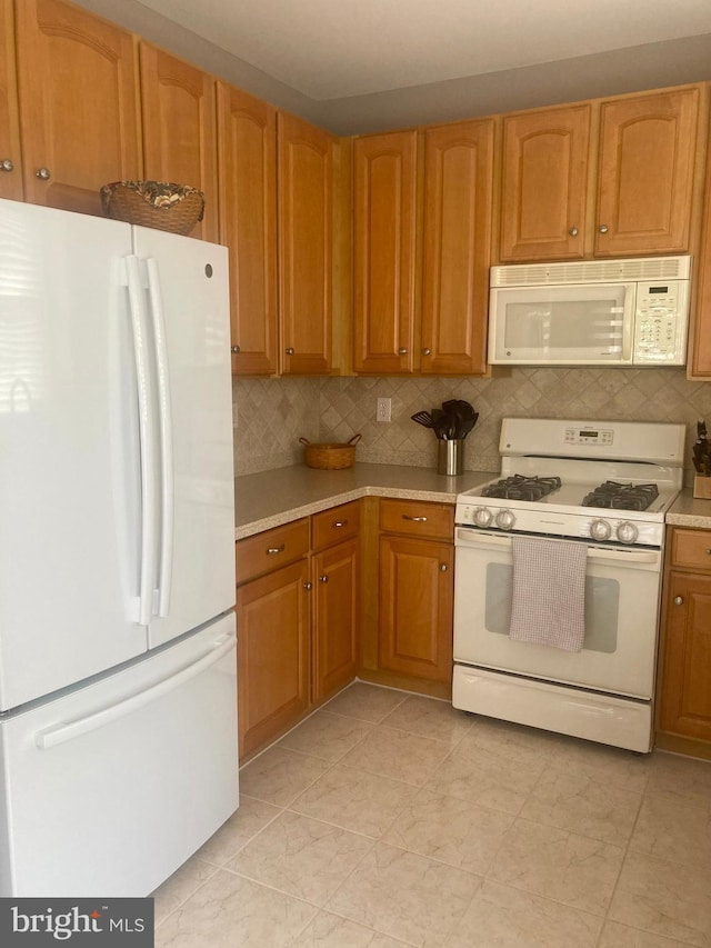 kitchen with white appliances, brown cabinetry, decorative backsplash, and light countertops
