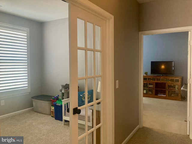 interior space featuring carpet flooring, baseboards, plenty of natural light, and french doors