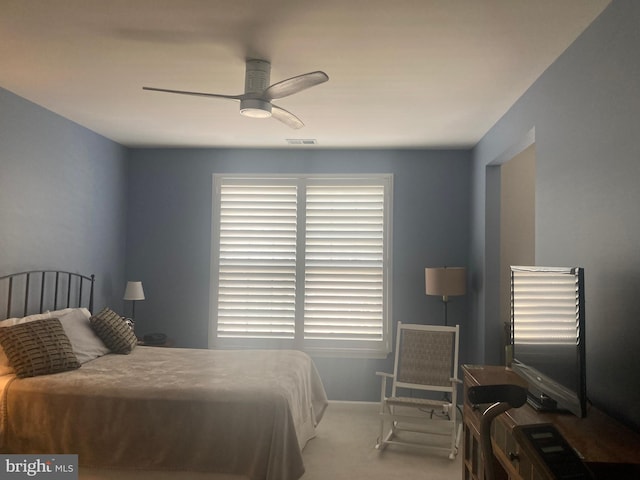 carpeted bedroom featuring baseboards, a ceiling fan, and visible vents