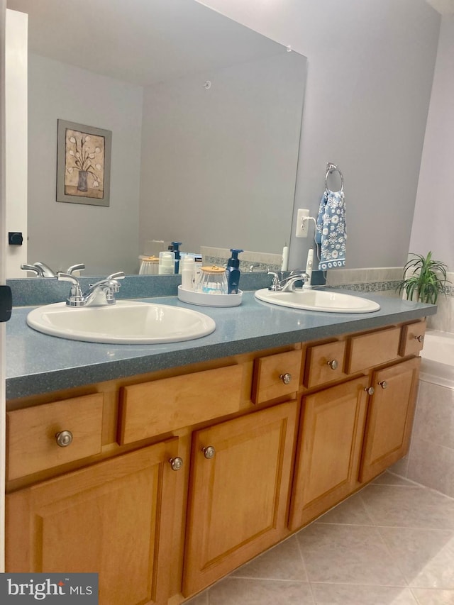 full bath with double vanity, a sink, and tile patterned flooring