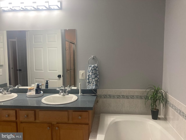 full bath featuring double vanity, a sink, and a bath