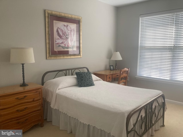bedroom featuring baseboards and light colored carpet