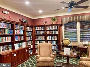 living area with wall of books, recessed lighting, and ceiling fan
