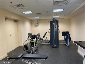 gym with baseboards, visible vents, and a paneled ceiling