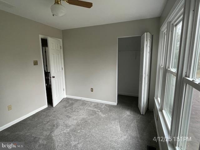 unfurnished bedroom featuring carpet floors, baseboards, a ceiling fan, and a closet