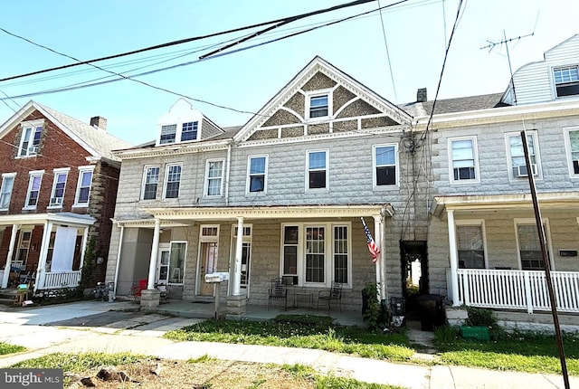 view of property with covered porch and stone siding