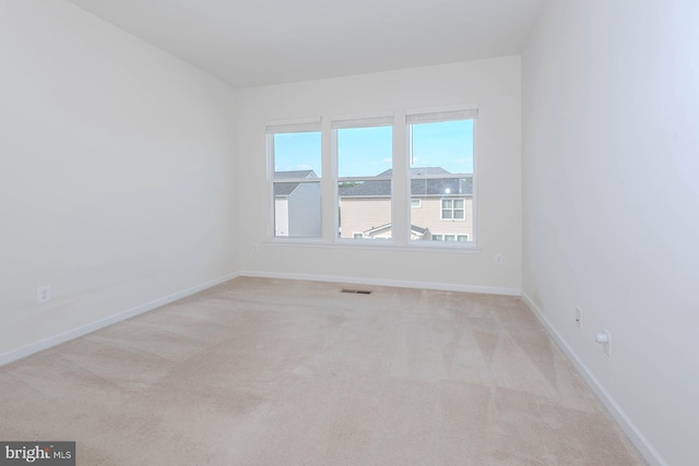carpeted spare room with baseboards and visible vents