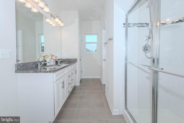 full bathroom with double vanity, tile patterned floors, a sink, and a stall shower