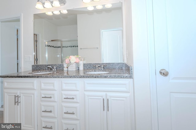full bathroom featuring double vanity, a sink, and a stall shower
