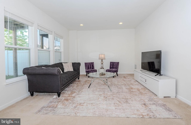 living area featuring light colored carpet, recessed lighting, and baseboards
