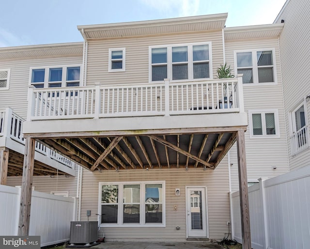 rear view of property featuring fence and central AC unit