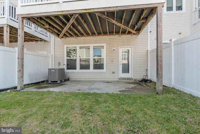 rear view of house featuring a lawn, a patio area, central AC, and fence