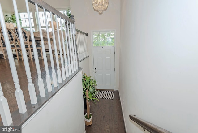 interior space featuring wood finished floors, a notable chandelier, and stairway