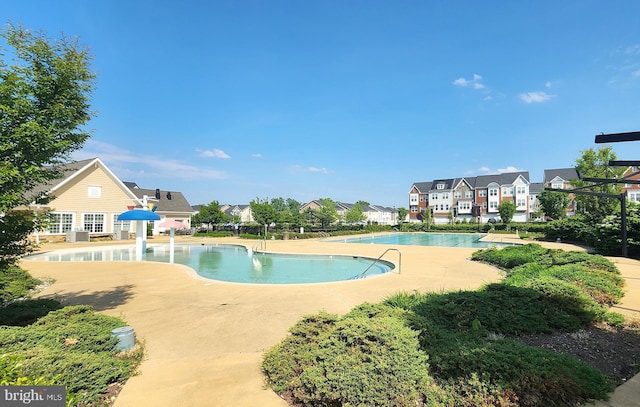 community pool with a residential view and a patio