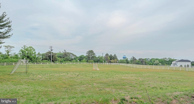 view of yard with fence and a rural view