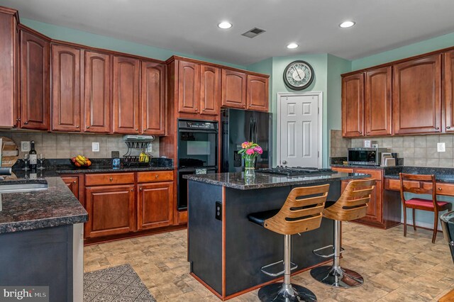 kitchen with black appliances, backsplash, a center island, dark stone countertops, and recessed lighting
