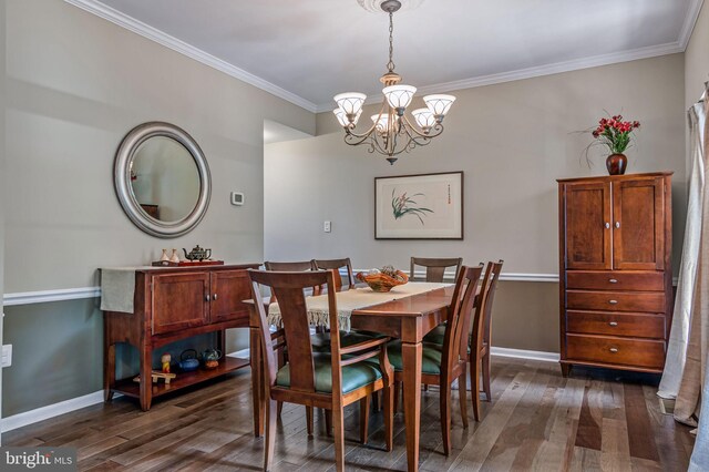 dining area featuring dark wood finished floors, a chandelier, baseboards, and ornamental molding