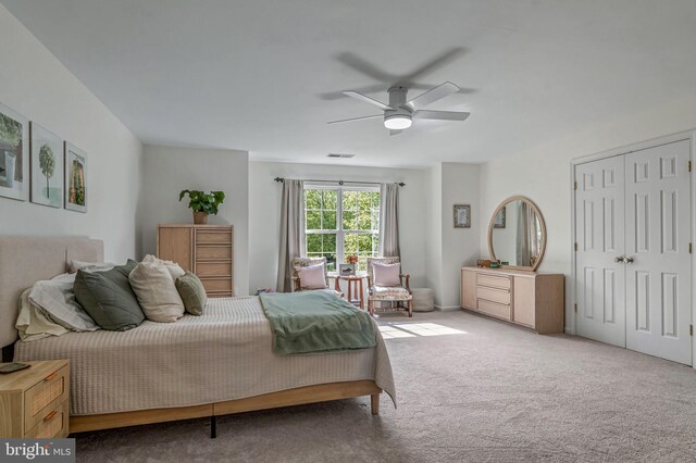 carpeted bedroom with a ceiling fan and a closet