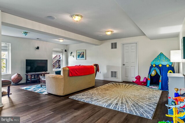 living area featuring plenty of natural light, wood finished floors, and baseboards