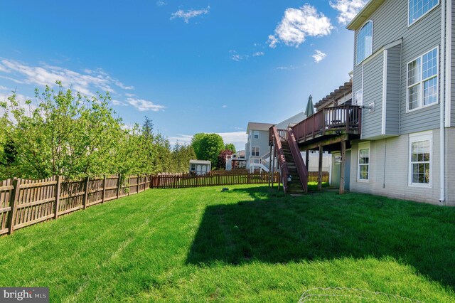view of yard with a wooden deck and stairs