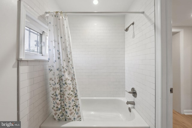 bathroom featuring wood finished floors and shower / tub combo