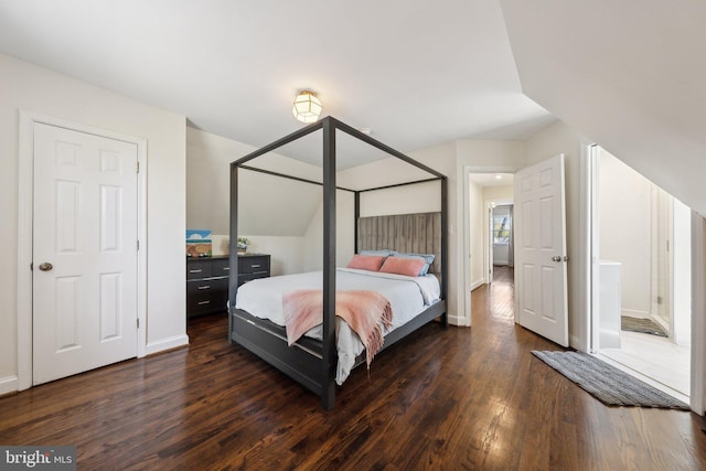 bedroom with baseboards, dark wood-style floors, and lofted ceiling