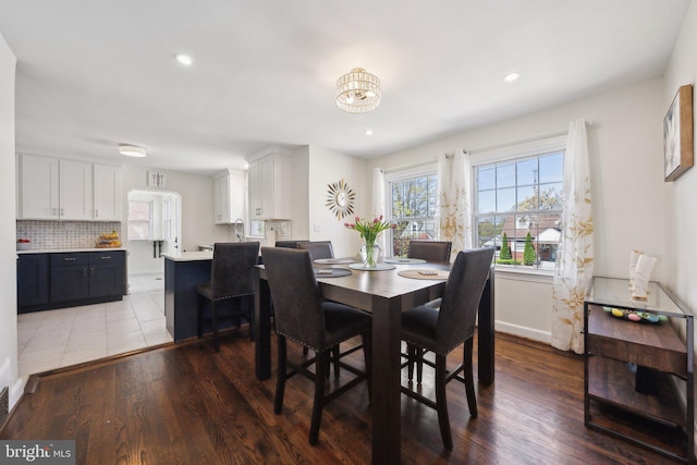dining space with recessed lighting, light wood-style flooring, baseboards, and an inviting chandelier